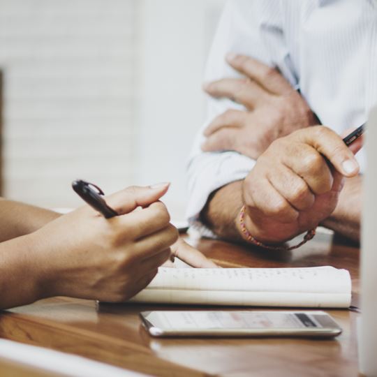 Staff members sat at a desk trying to work out an induction timetable